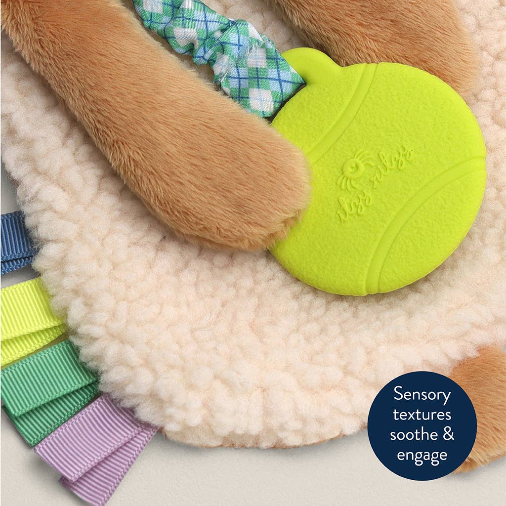 Close up detail of a plush puppy lovey with a green teether attached to it, designed for babies.