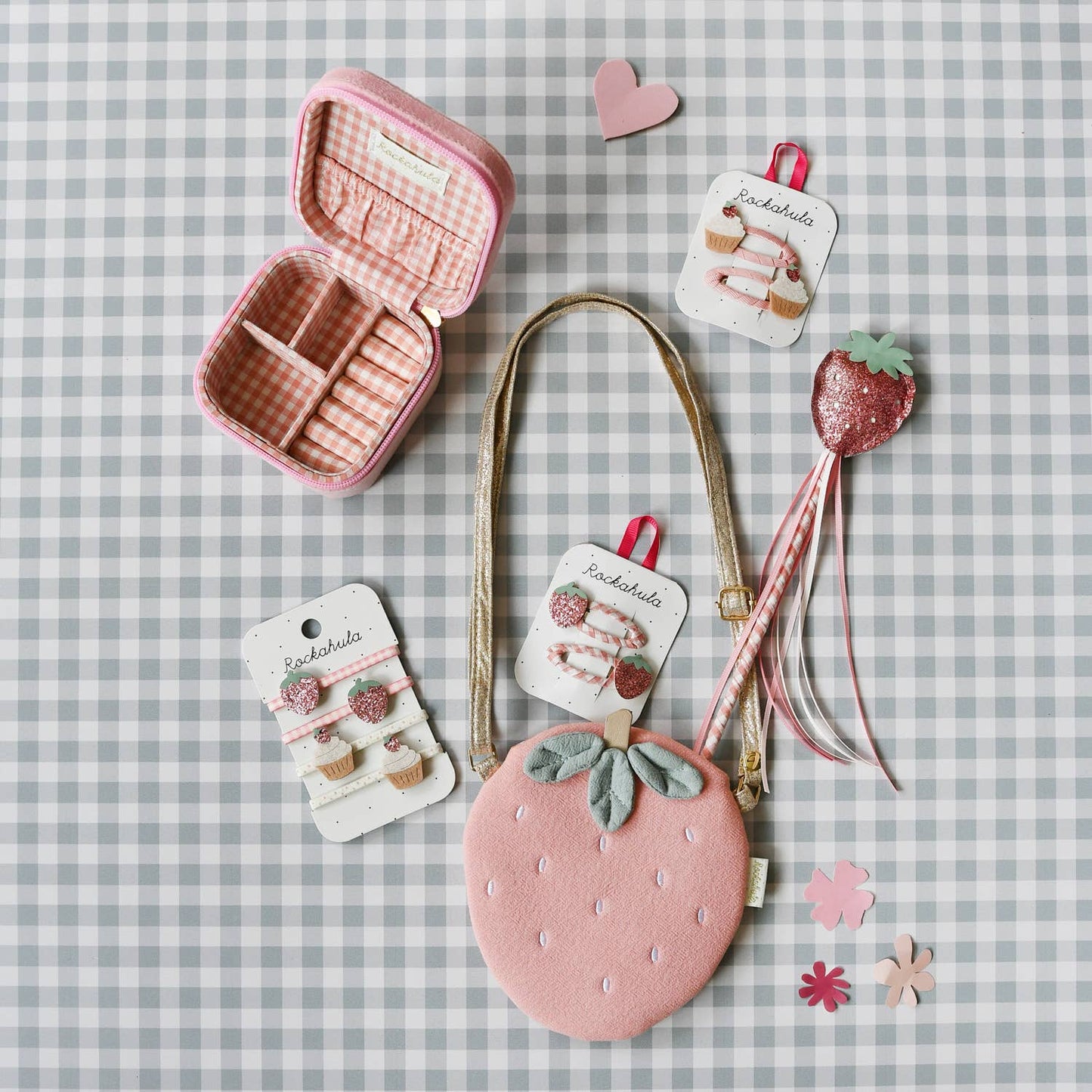 Strawberry themed dress up items on a green gingham background.