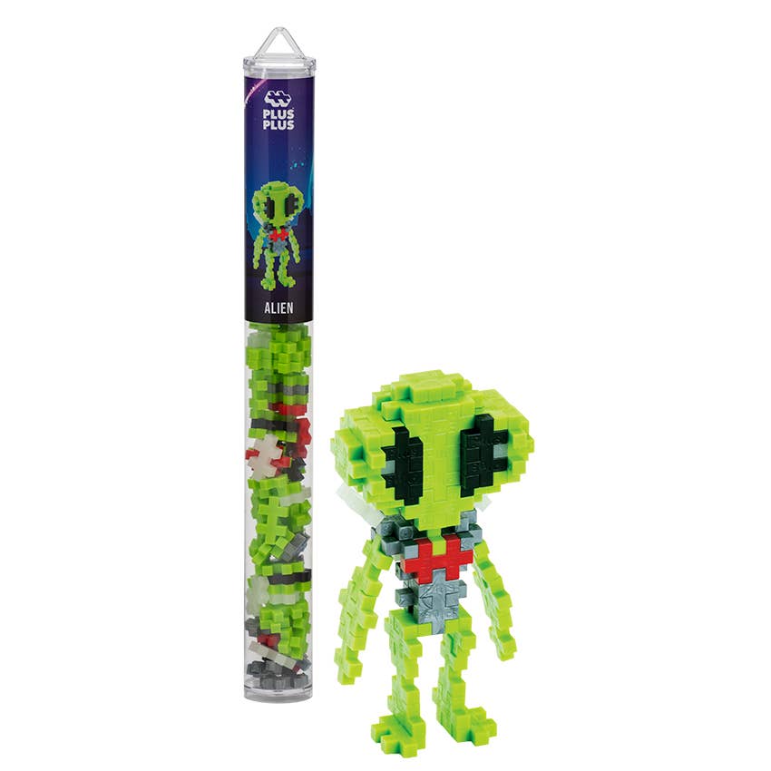 Puzzle figure of an alien made from building blocks with packaging on a white background