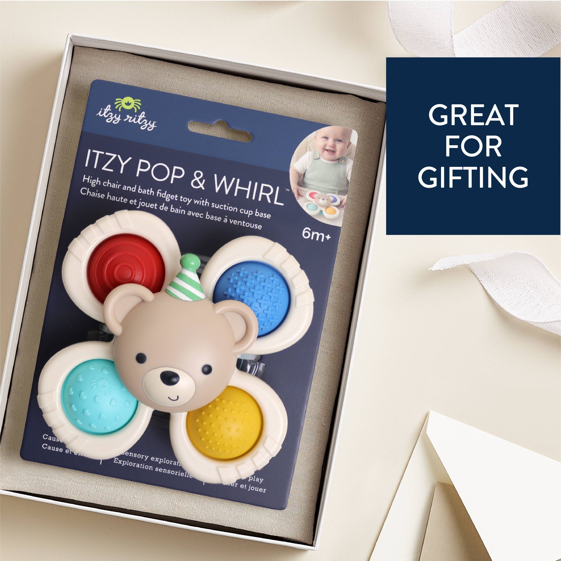 Boxed baby teething toy set labeled 'ITZY POP & WHIRL,' shown in an open gift box with a bear-shaped central toy and four colorful circular teethers. A navy badge on the right says 'GREAT FOR GIFTING.'