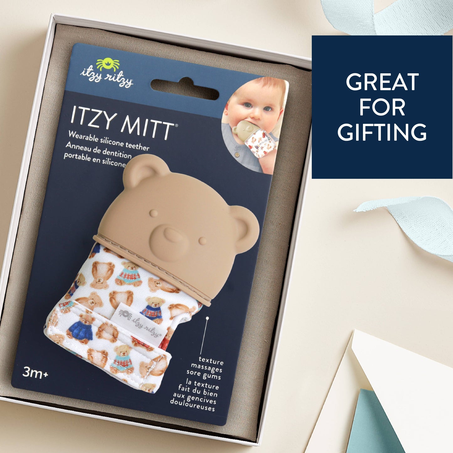 ITZY MITT wearable silicone teether packaging with a baby image on a beige background