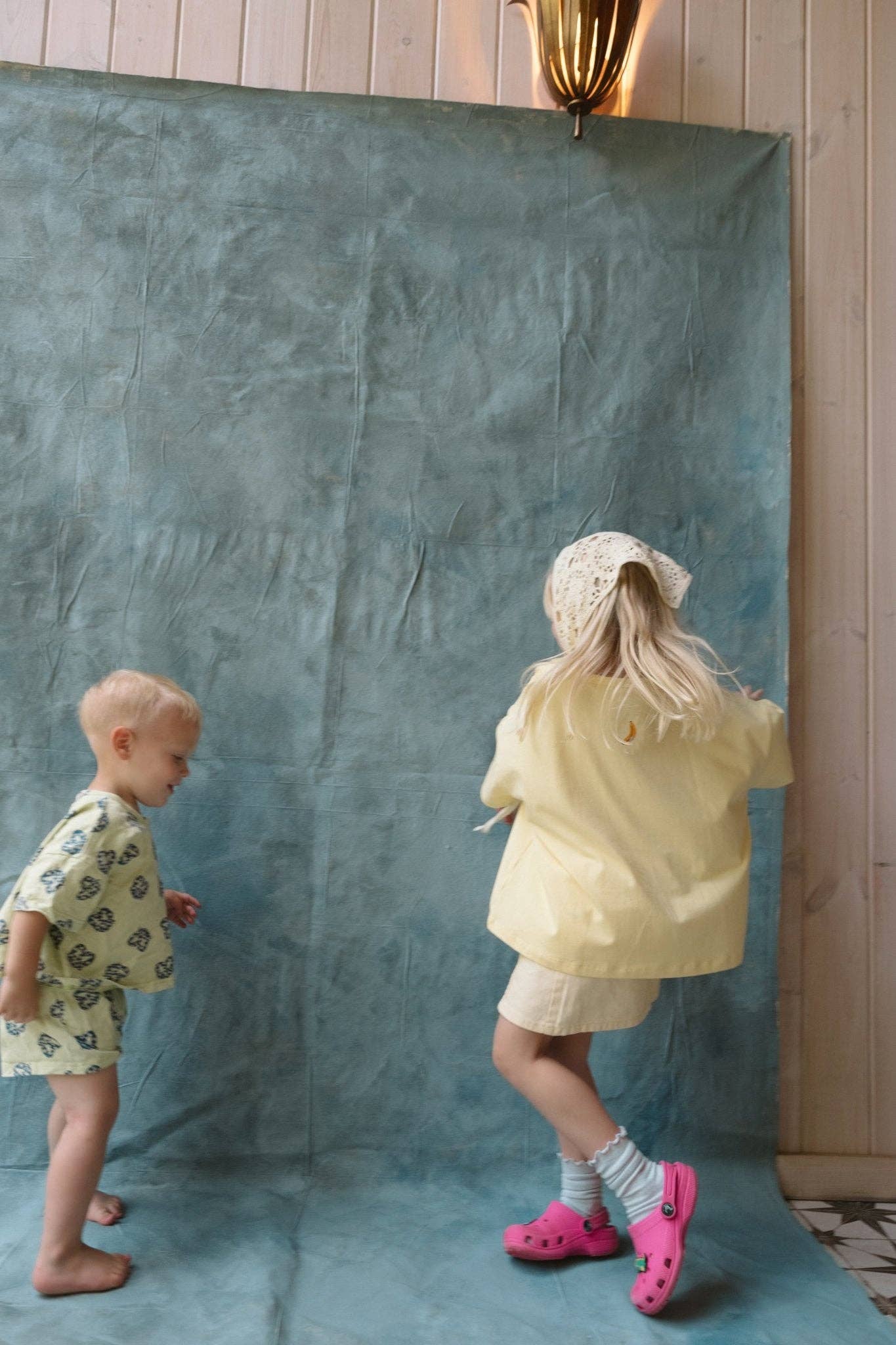 Two children in front of a textured green backdrop