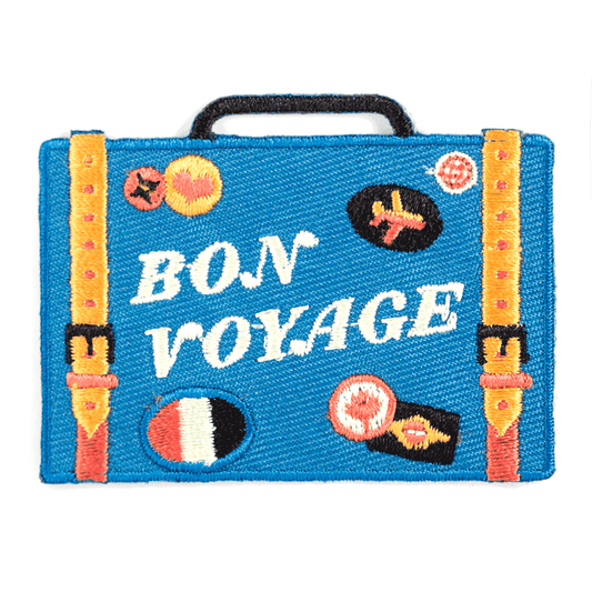 Blue suitcase-shaped pouch with 'Bon Voyage' text and colorful designs on a white background