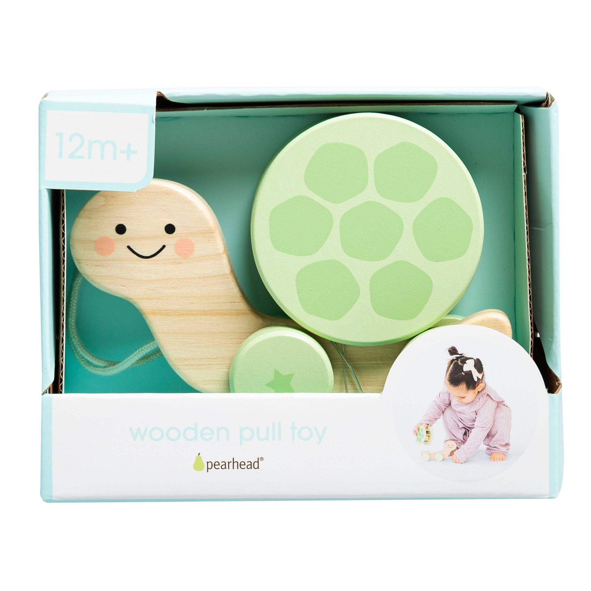 Wooden pull toy with green and beige elements in a Pearhead box