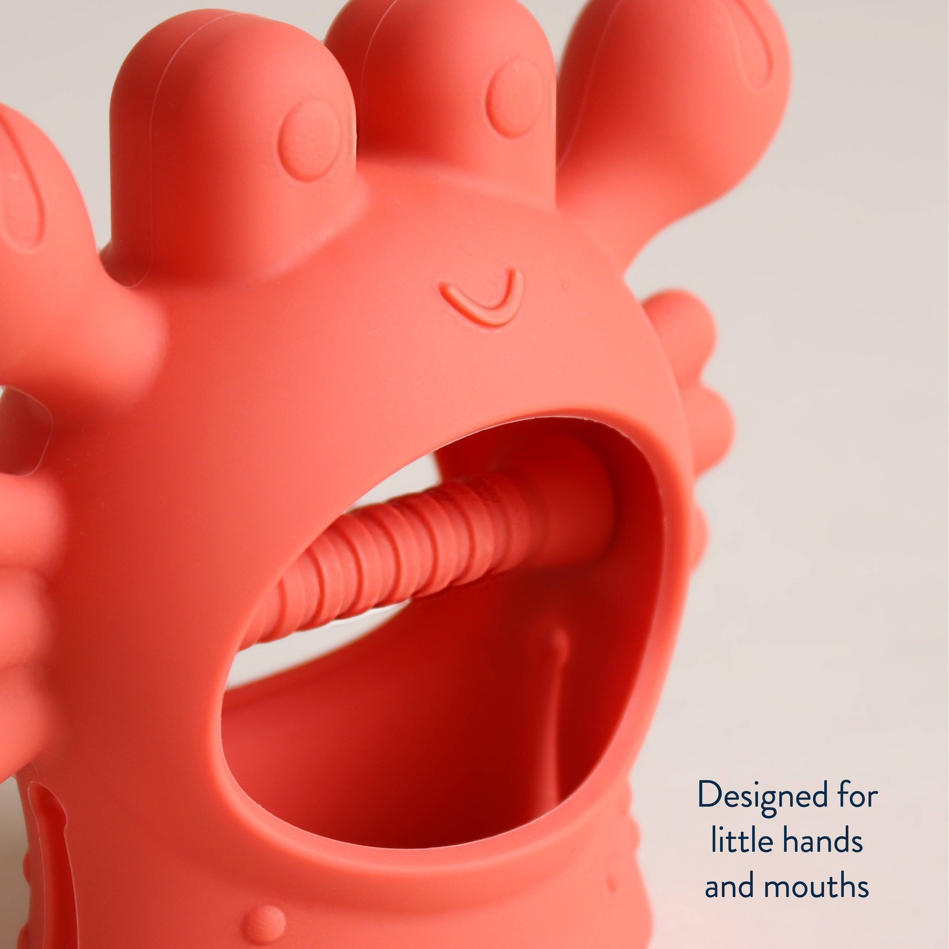 Red silicone teething toy with a neutral background