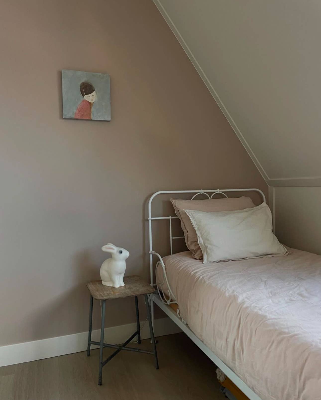 Small bedroom with a bed, nightstand, and wall art.