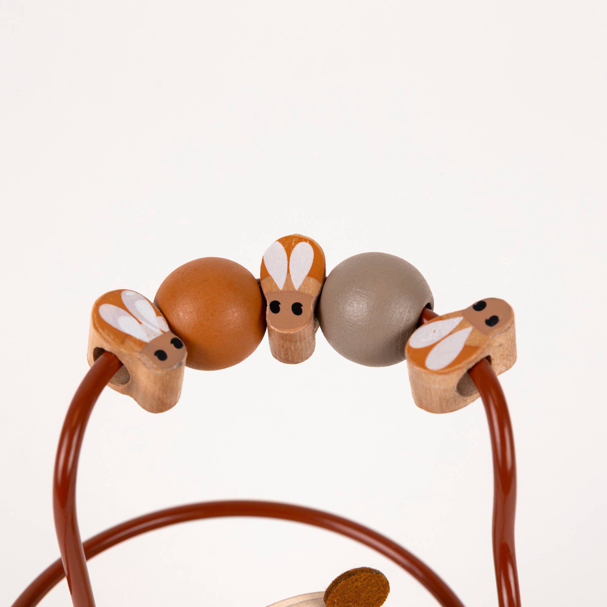 Wooden toy with bee shaped beads on a white background