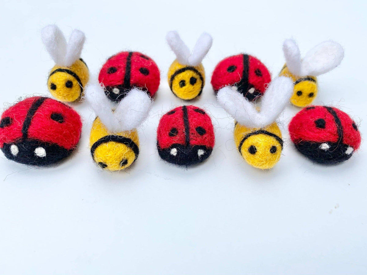 Set of small plush toys shaped like ladybugs and bees on a white background