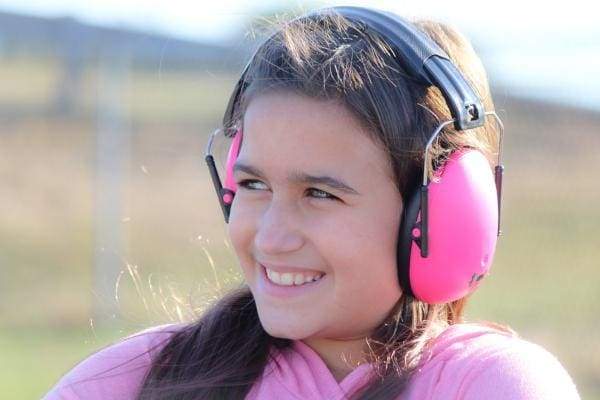 Person wearing pink ear protection in an outdoor setting