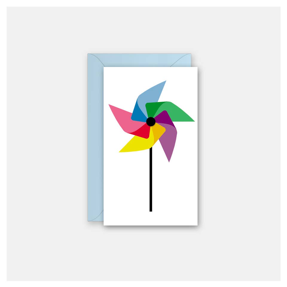 A white mini greeting card featuring a colorful pinwheel design with pink, blue, green, yellow, and purple blades, shown with a light blue envelope behind it on a light gray background.