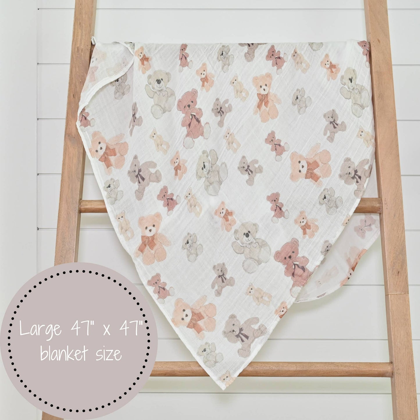 Teddy bear patterned blanket draped over a wooden ladder on a white background
