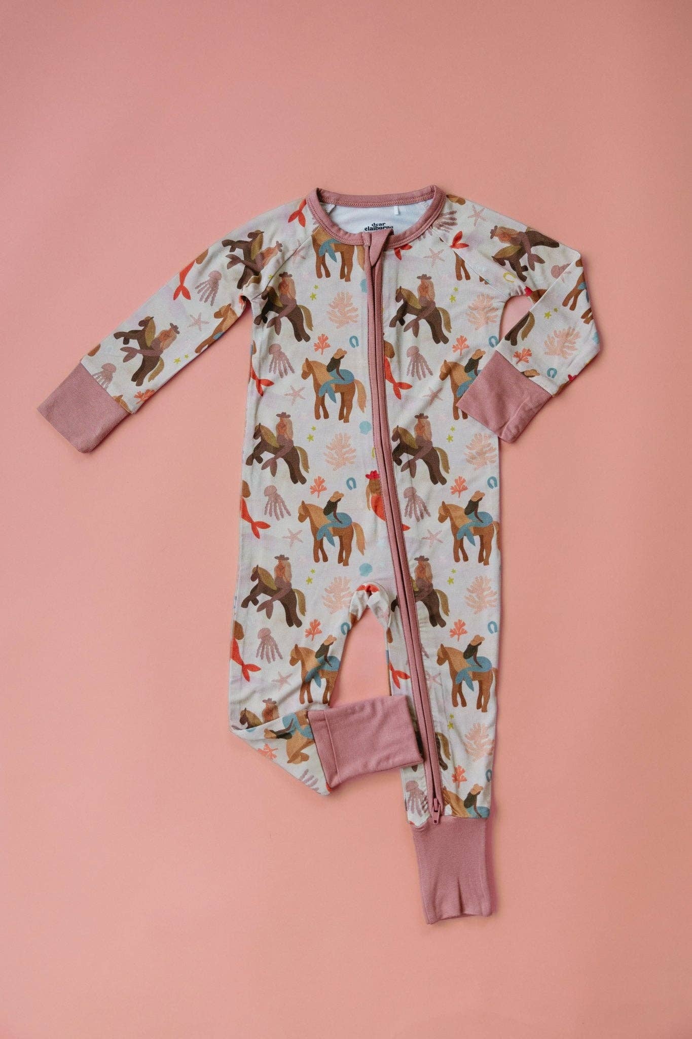 Children's onesie with mermaid cowboy pattern on a pink background