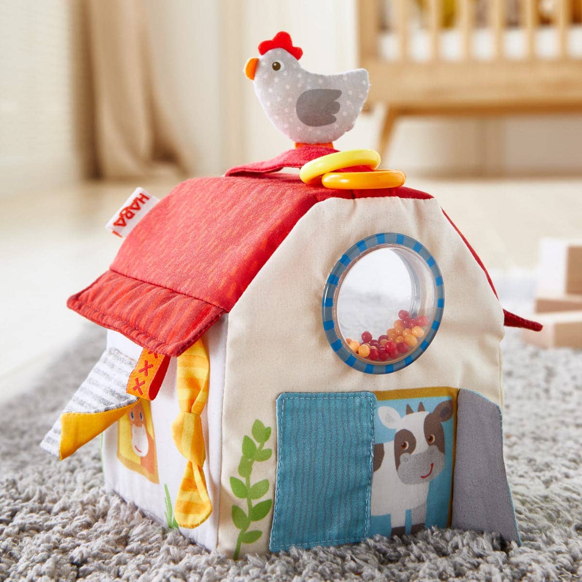 Children's toy with a chicken design on top, placed on a carpeted floor.