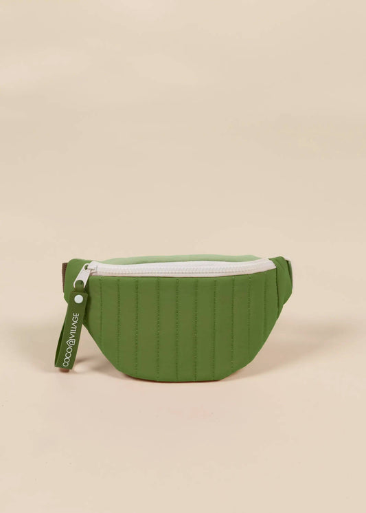 Green waist bag with a white zipper on a beige background
