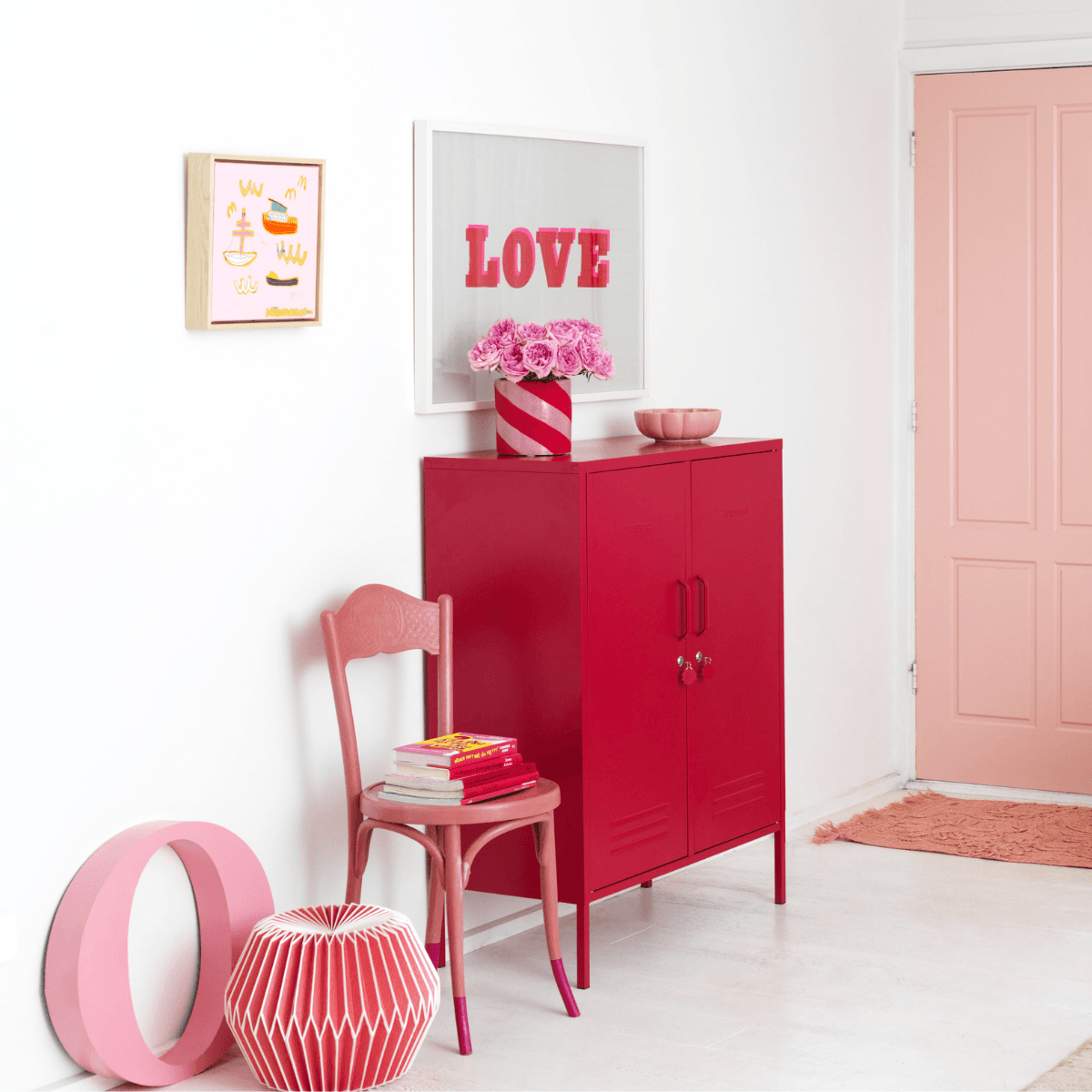 Red cabinet, chair, and decorative items in a room with a 'LOVE' sign.