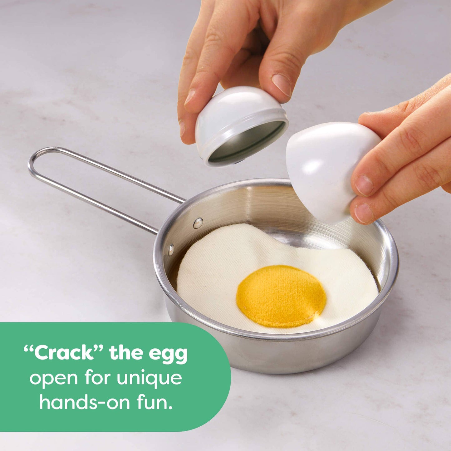 Person using a small white device to crack an egg over a sunny-side-up egg in a metal pan.