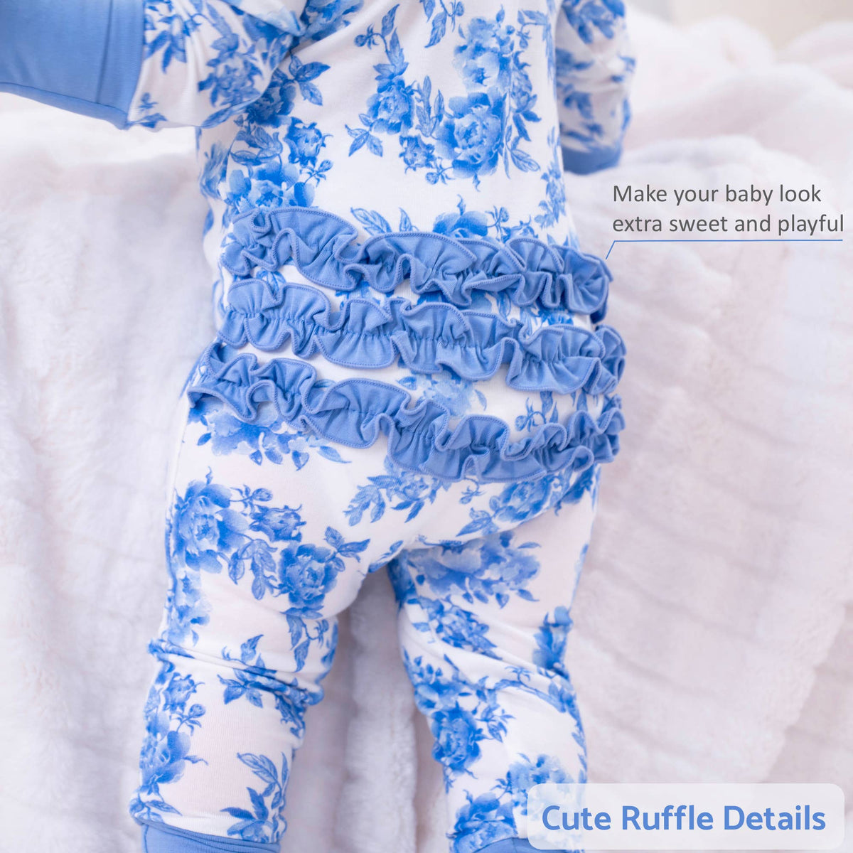A baby outfit featuring a white and blue floral print with multiple ruffle details, shown on a doll or mannequin against a soft white background. Text overlays highlight the ruffle details.