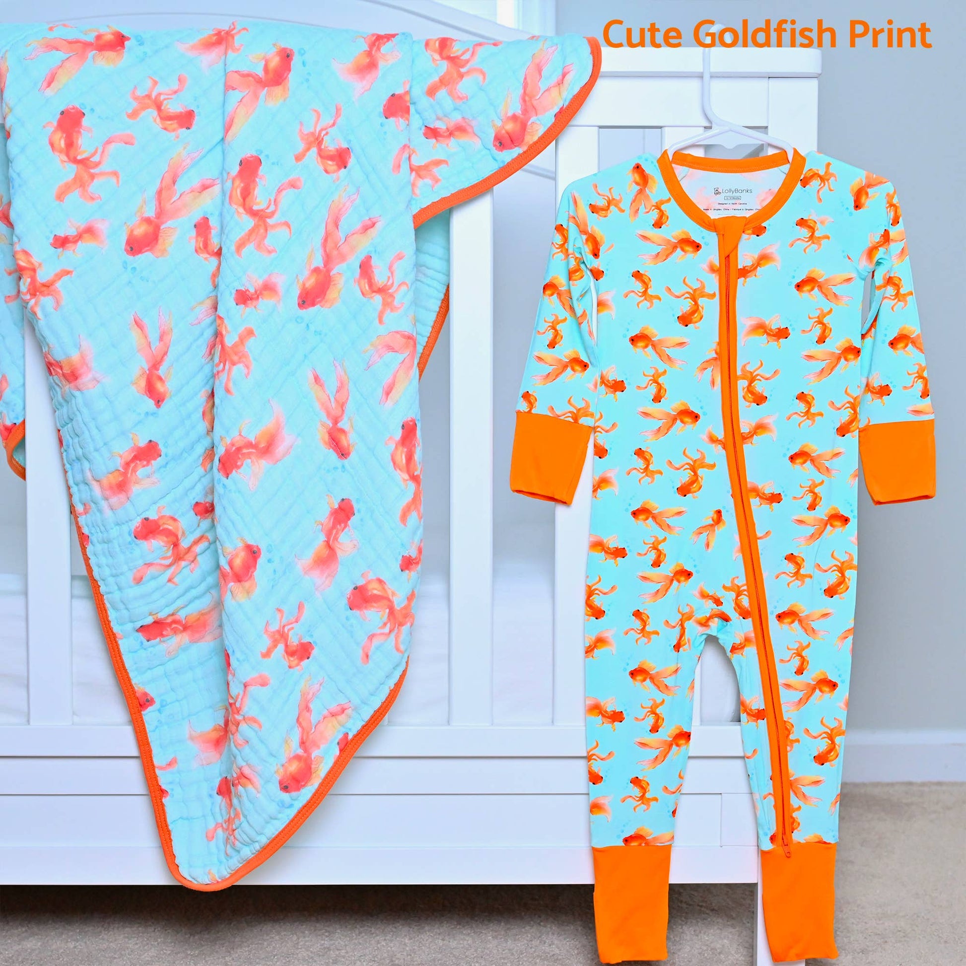 Children's pajama onesie with goldfish pattern on a hanger against a white background