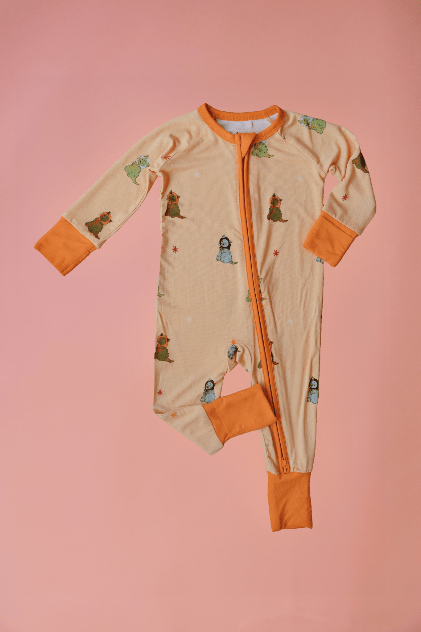 Baby onesie with cartoon characters on a pink background