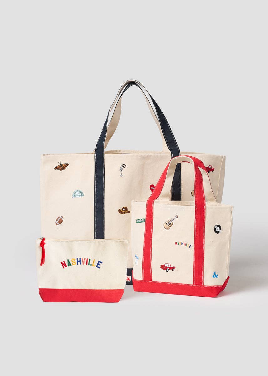 A set of three canvas tote bags in cream, navy, and red, decorated with small colorful illustrations and featuring the word 'NASHVILLE' on the front of the smallest bag, photographed on a light gray background.