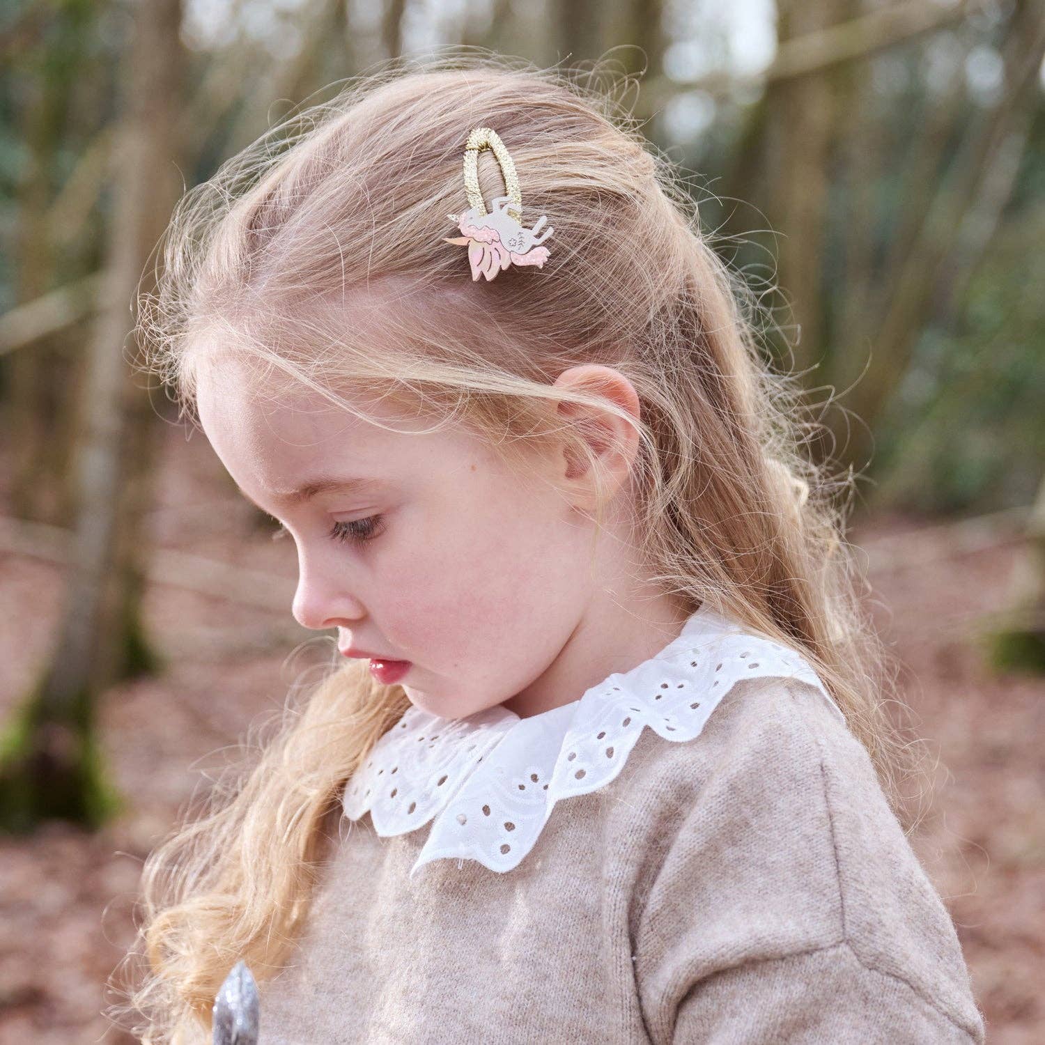 Young girl with a unicorn hair clip outdoors