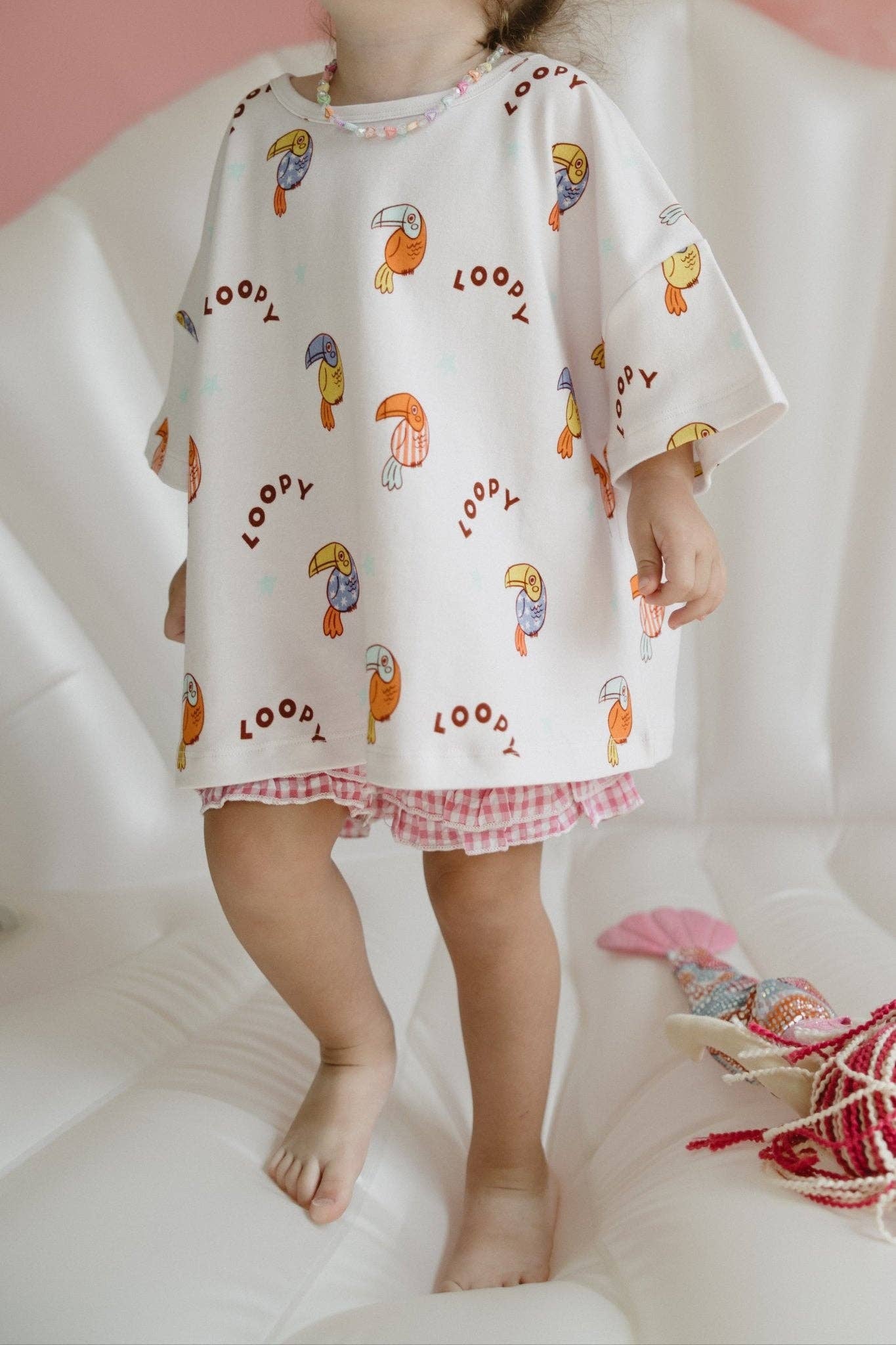 Child wearing a patterned outfit with a white background