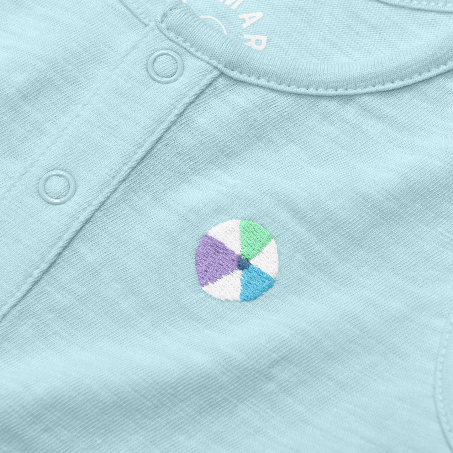 Close-up of a light blue fabric with a colorful wheel design and brand name.