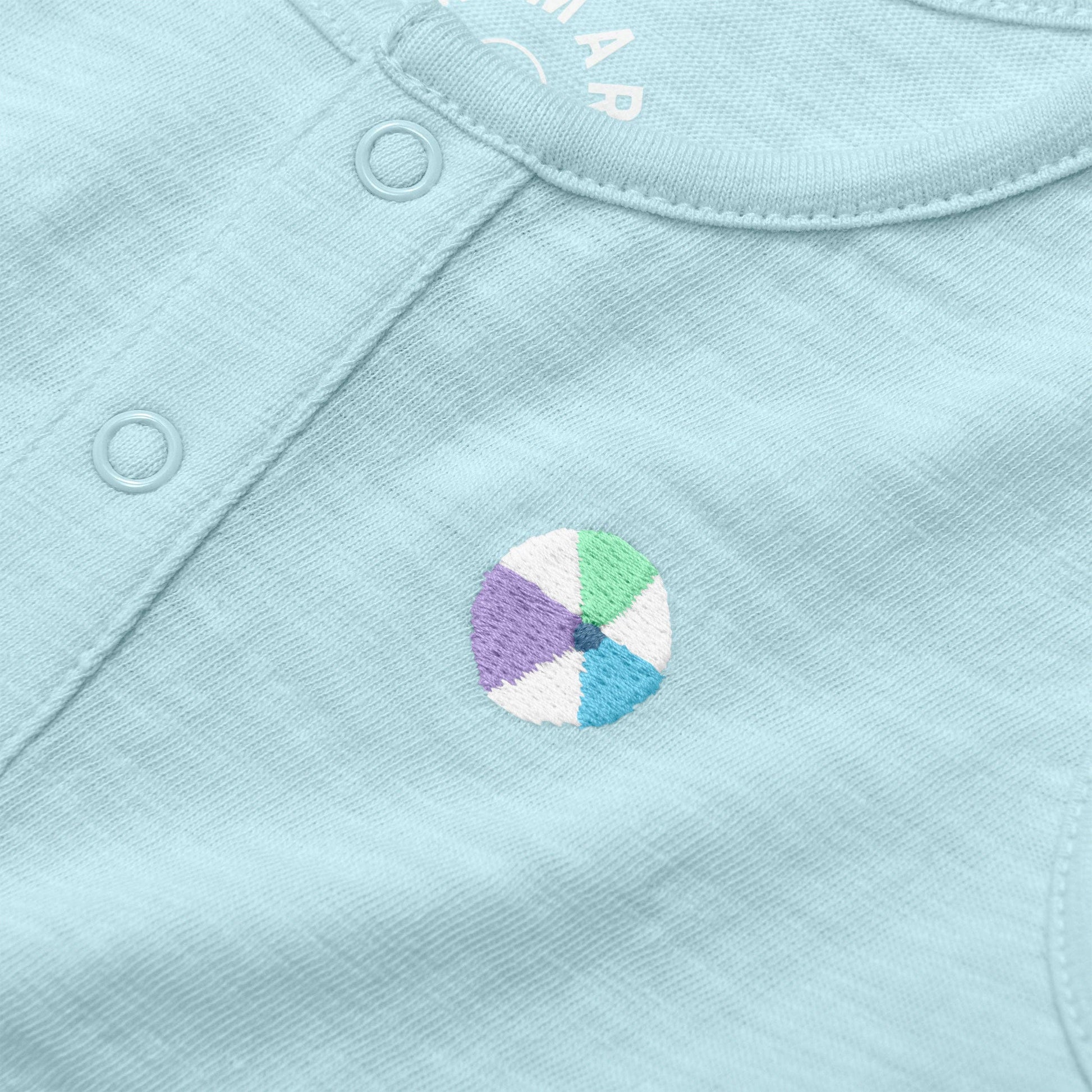 Close-up of a light blue fabric with a colorful wheel design and brand name.