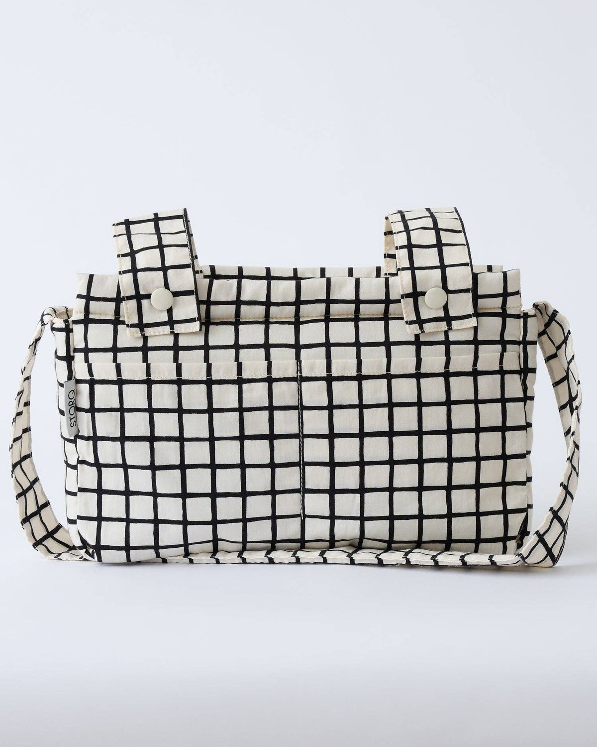 A black and white grid-patterned canvas tote bag with top handles and a shoulder strap, shown against a plain white background.