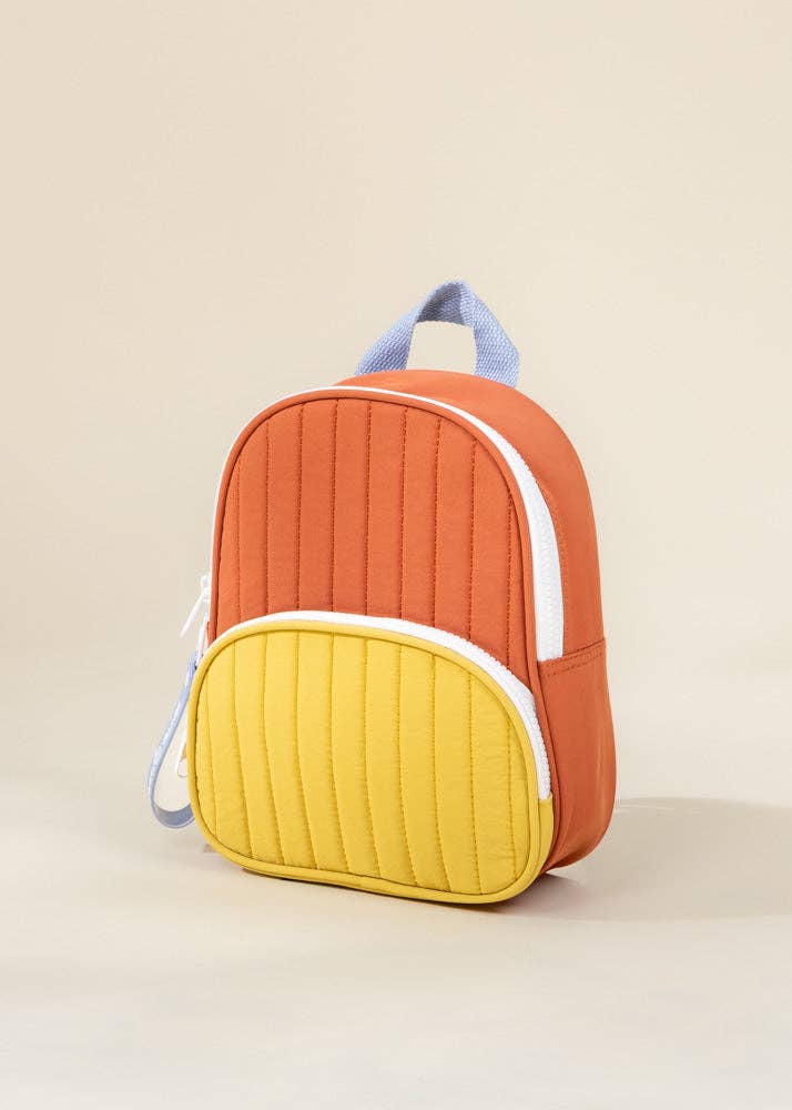 Colorful backpack with orange and yellow design on a beige background