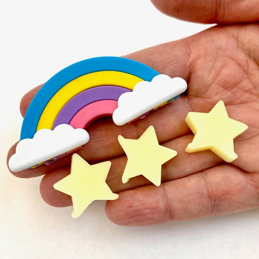 Colorful rainbow and cloud erasers held in a hand with yellow star-shaped erasers.