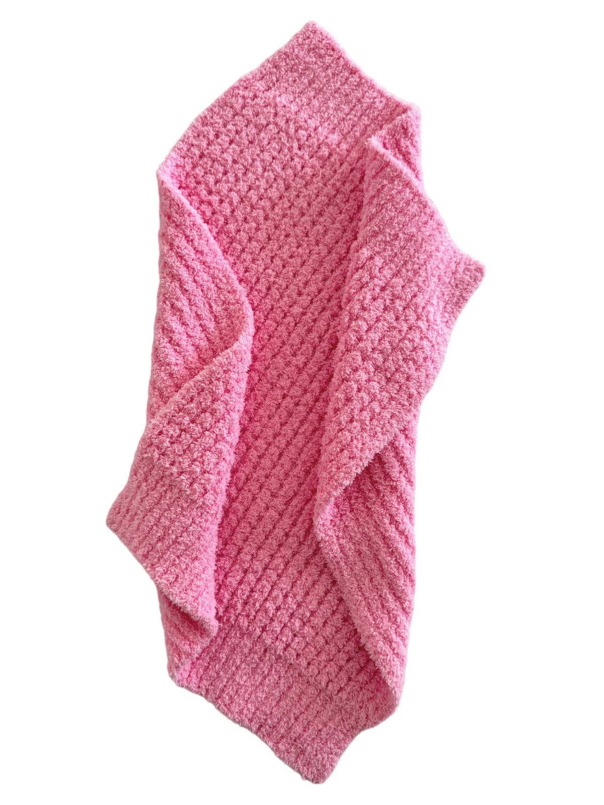 Pink textured baby blanket on a white background