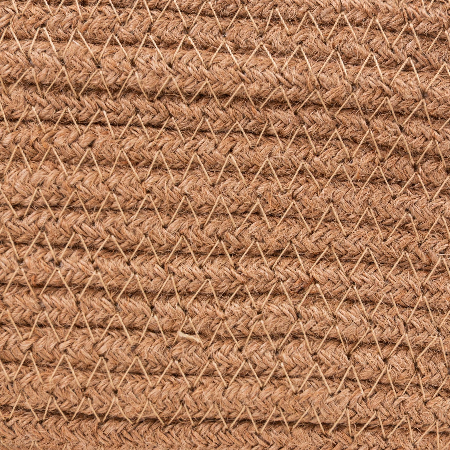 A close-up of a woven natural fiber material, likely jute or coir, in a warm tan-brown color, showing a textured chevron pattern.
