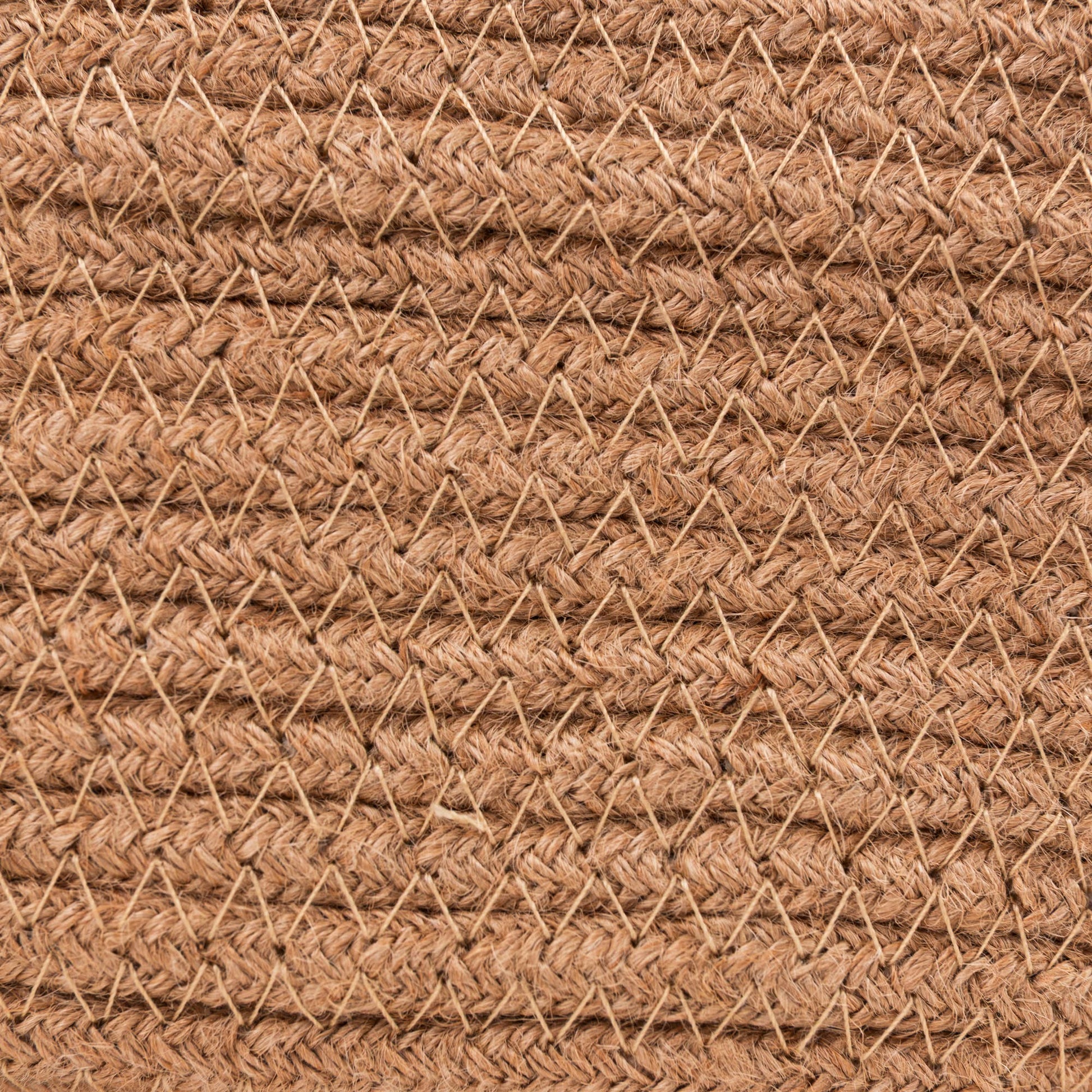 A close-up of a woven natural fiber material, likely jute or coir, in a warm tan-brown color, showing a textured chevron pattern.