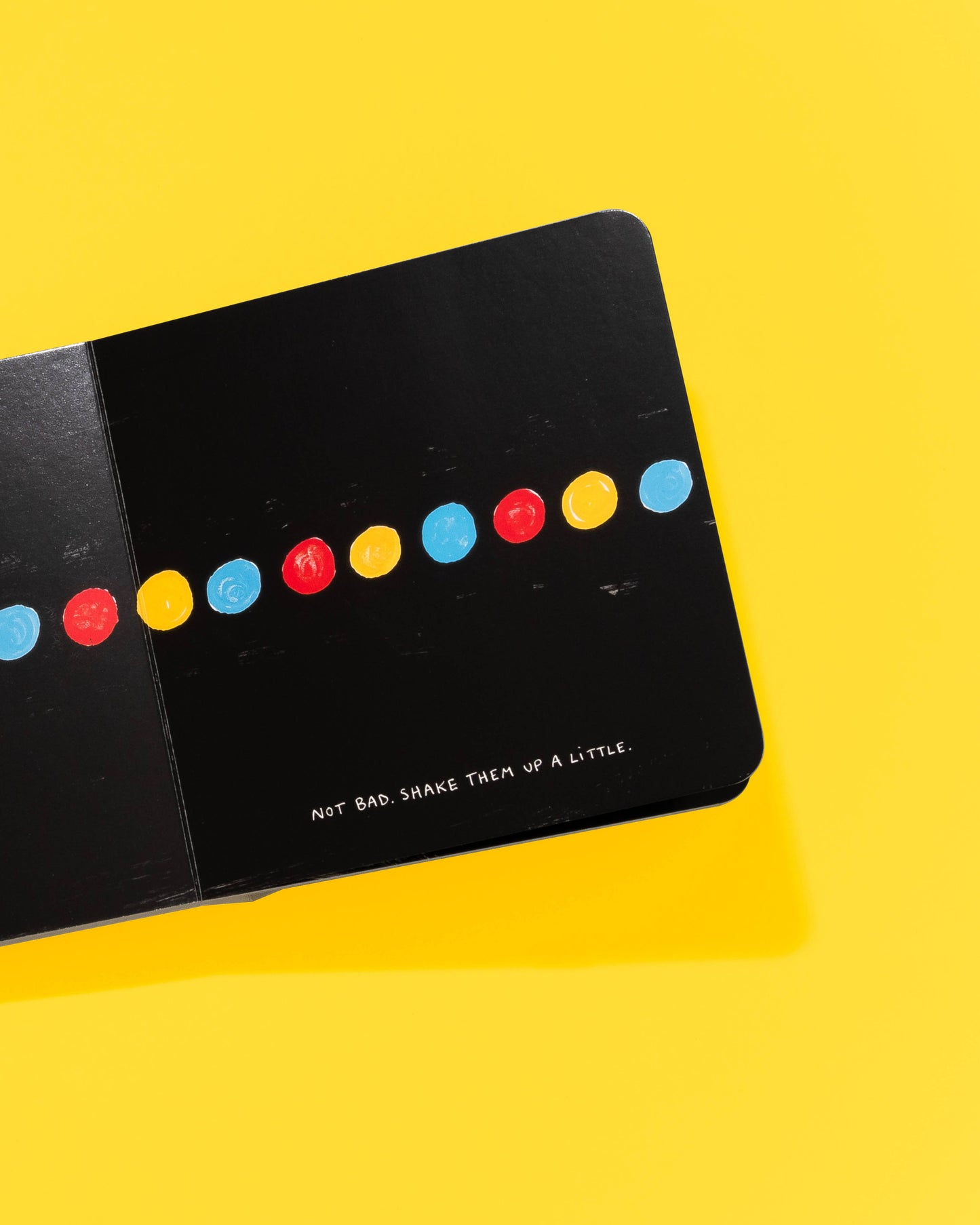 Black card with colorful dots and text on a yellow background