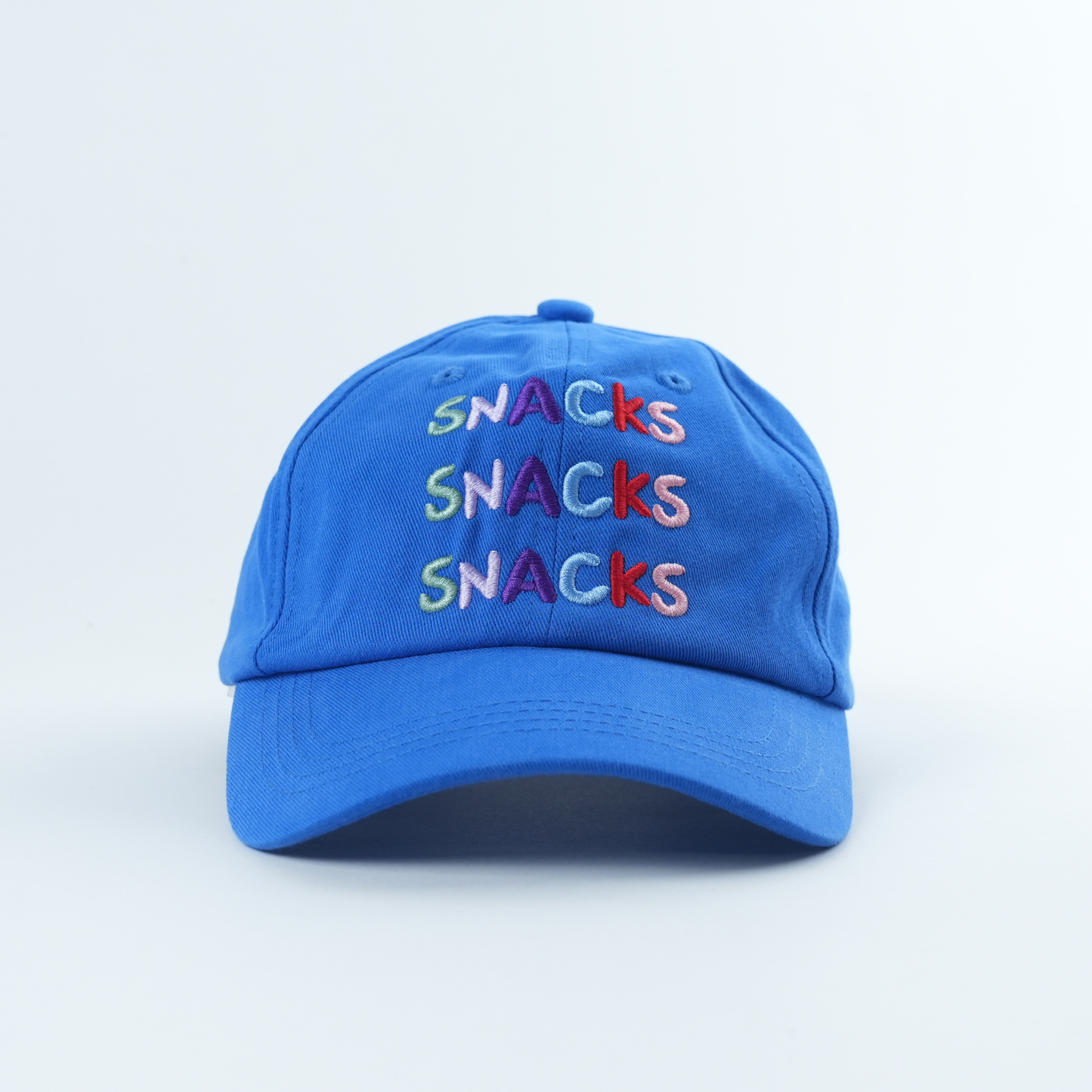 Blue cap with 'SNACKS' text in colorful letters on a light blue background