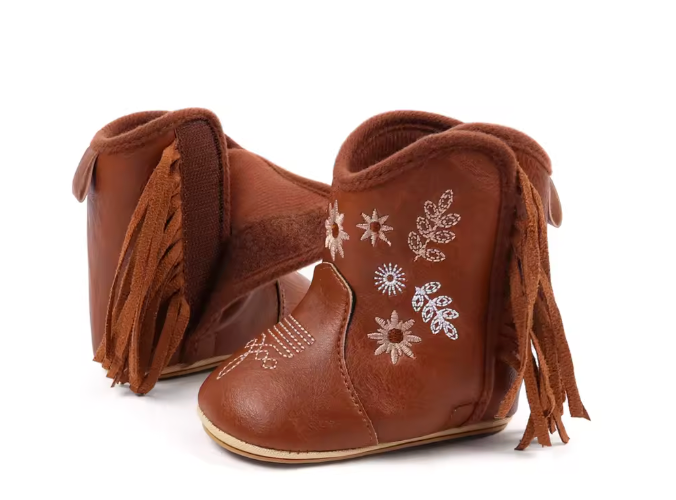 Pair of brown baby boots with fringe and floral embroidery on a white background