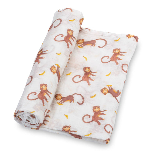 Rolled up baby swaddle blanket with monkey and banana pattern on a white background