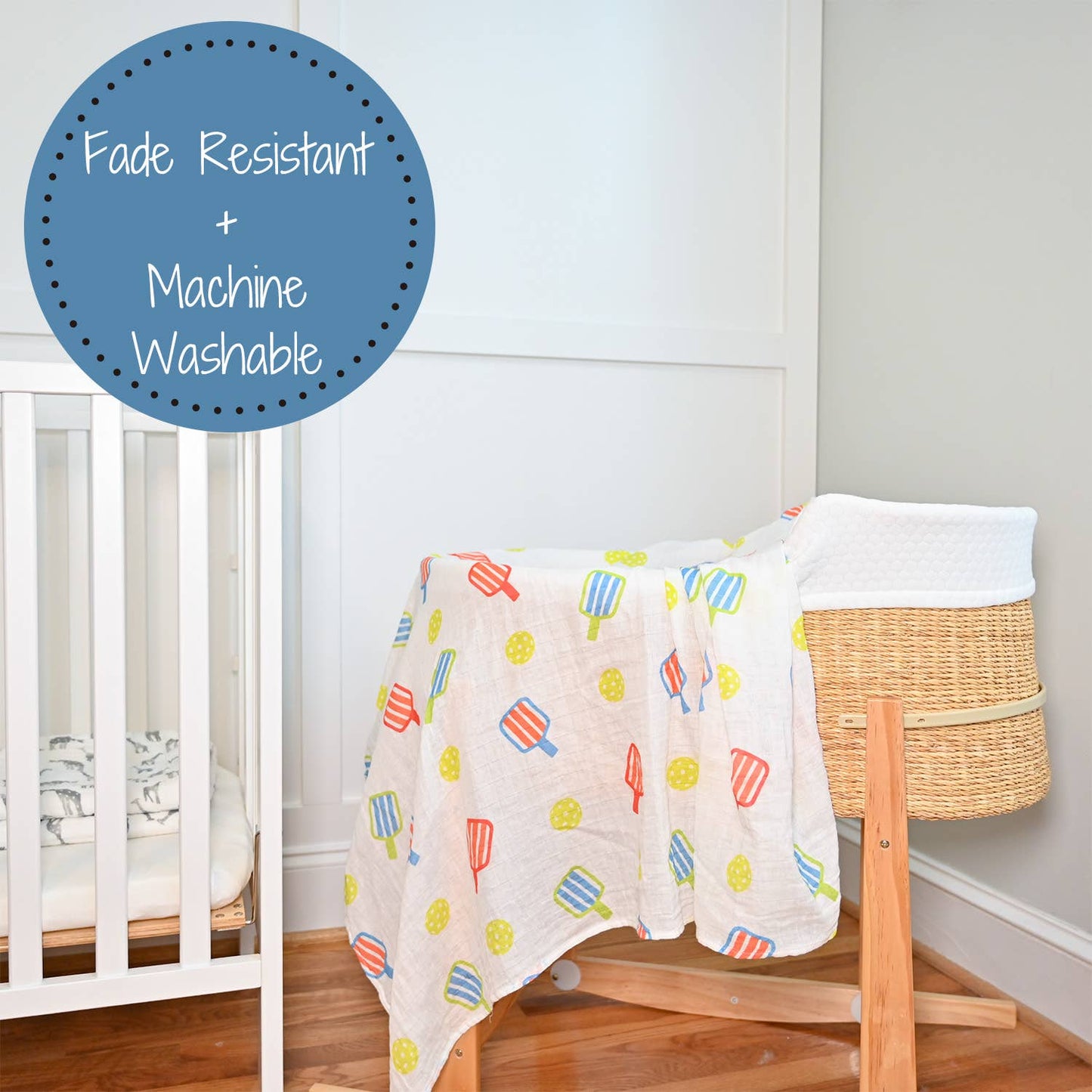 Baby blanket with colorful patterns draped over a crib in a nursery setting.