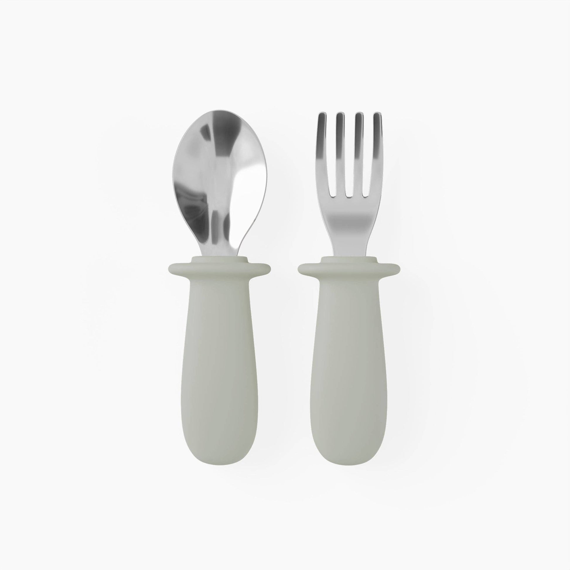 Silver spoon and fork with white handles on a white background