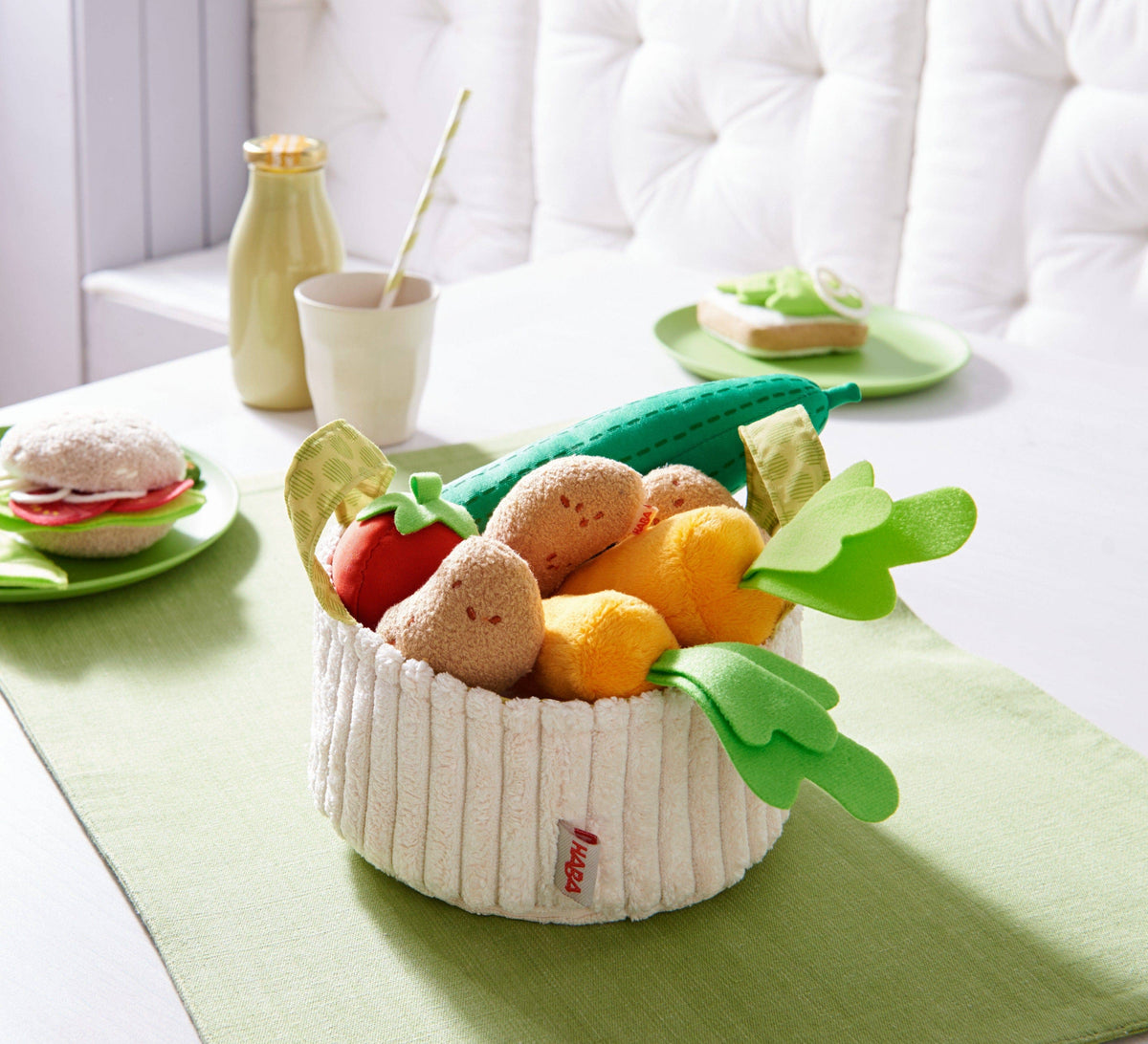Toy vegetables in a basket on a table with a white background