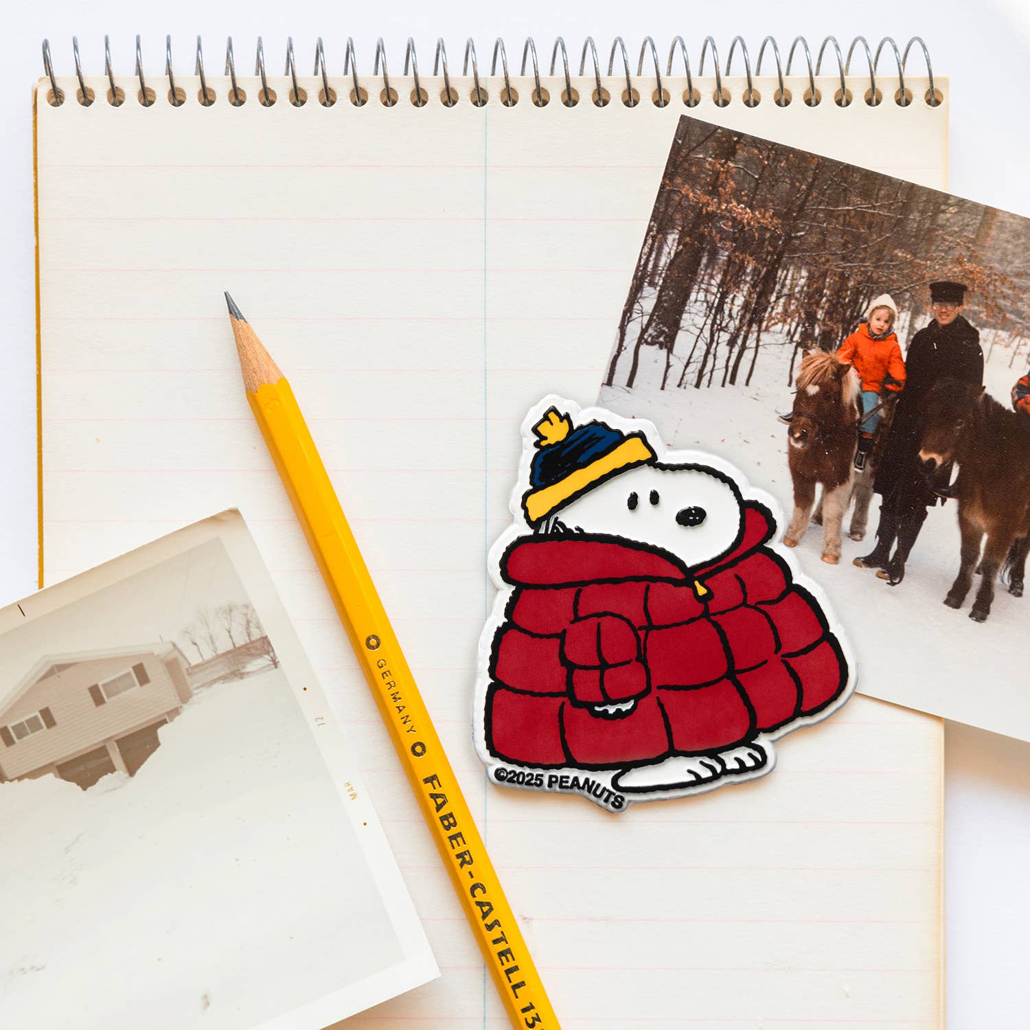 Sticker of a cartoon character in a red coat with a yellow pencil on a notebook