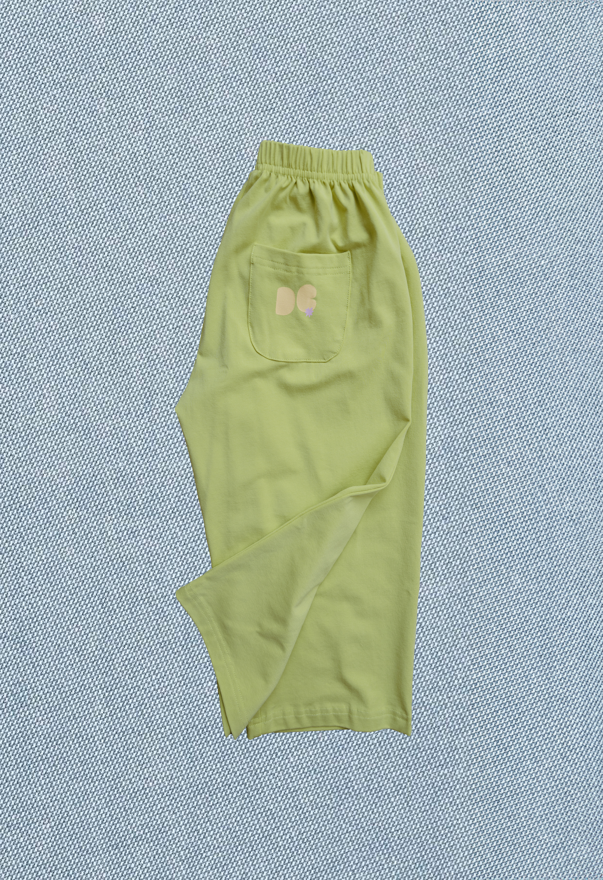 Green pants with a pocket on a textured blue background