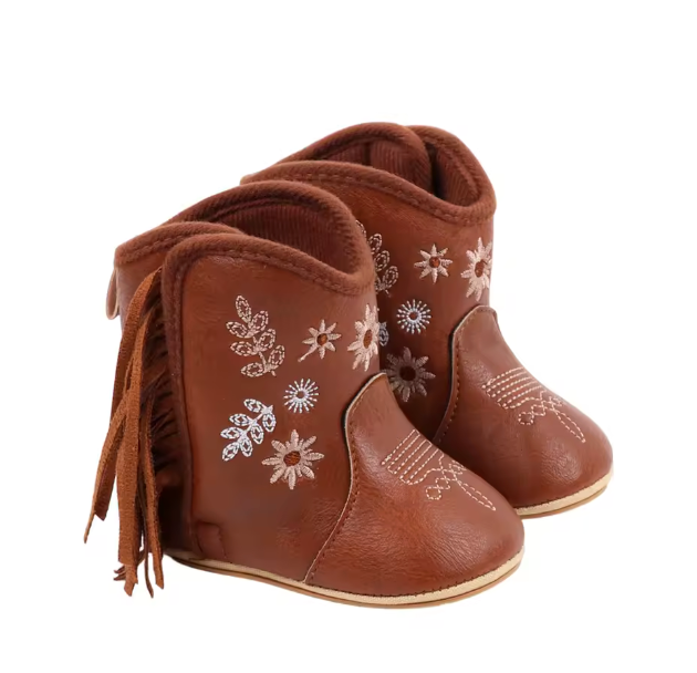 Pair of brown baby boots with floral patterns and fringes on a white background