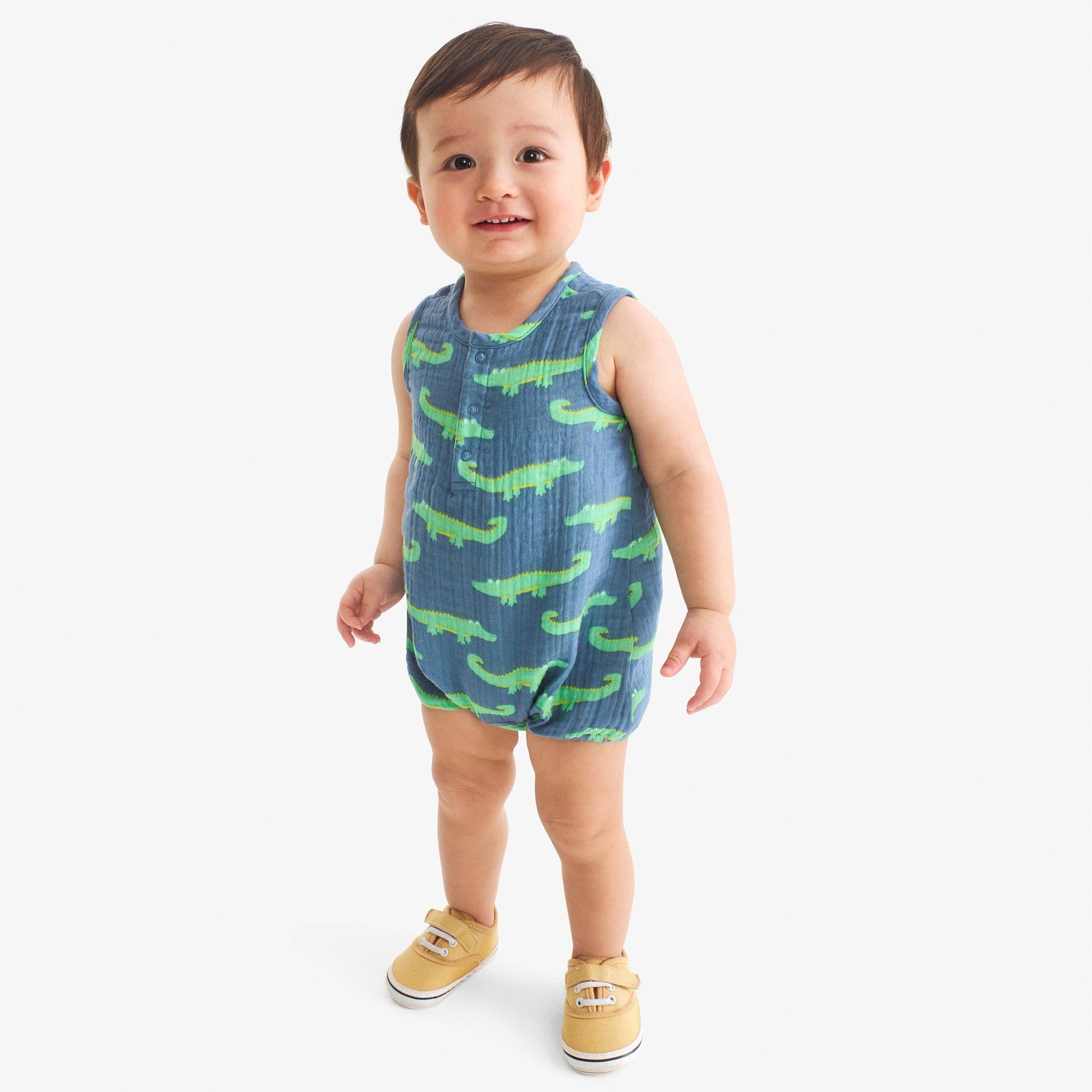 Baby wearing a blue and green patterned outfit on a white background