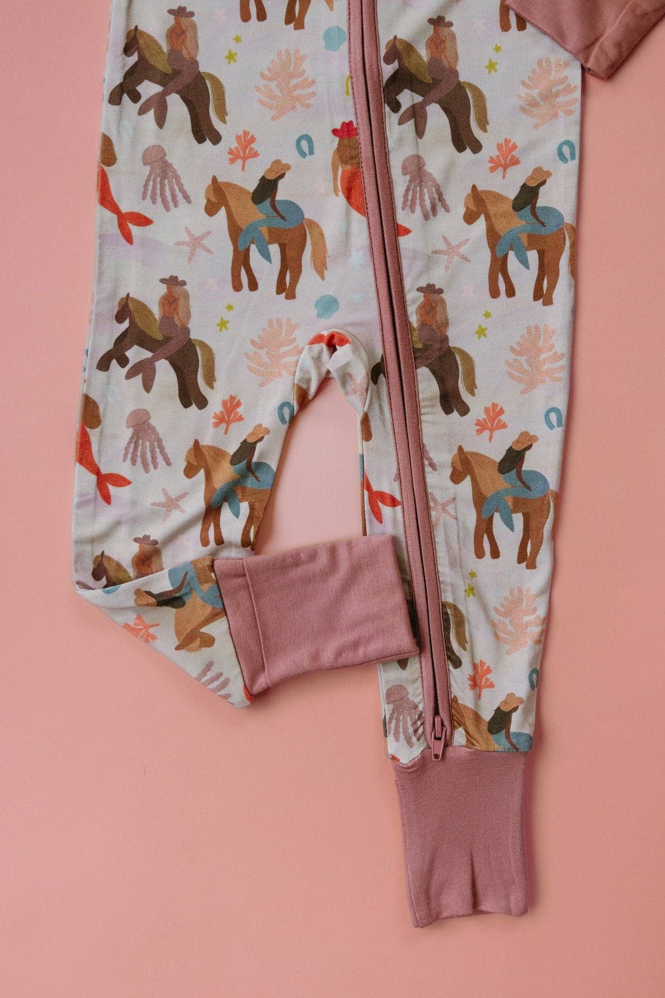 Children's onesie with horse pattern on a pink background