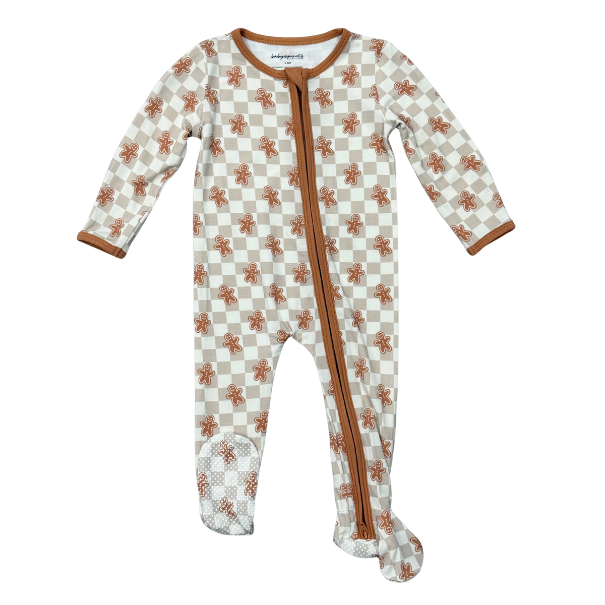 A baby footed sleeper with a brown and beige checkered pattern and small gingerbread motifs, featuring a brown zipper down the front and matching brown trim.