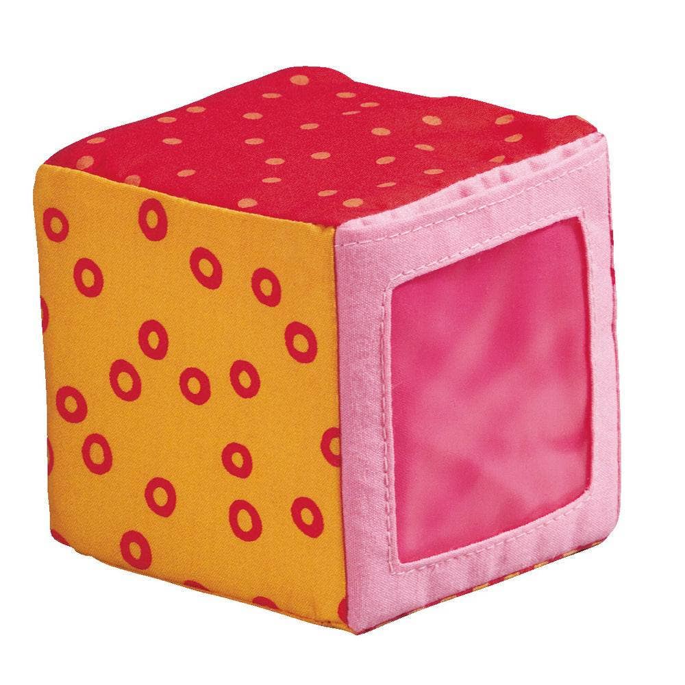 Colorful cube-shaped block with red polka dots on a white background