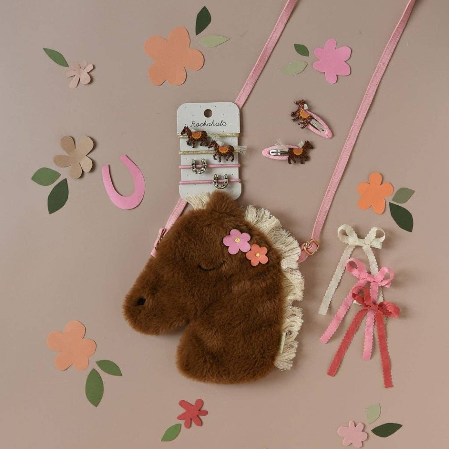 Brown plush horse headband with decorative elements on a beige background with flowers and ribbons.