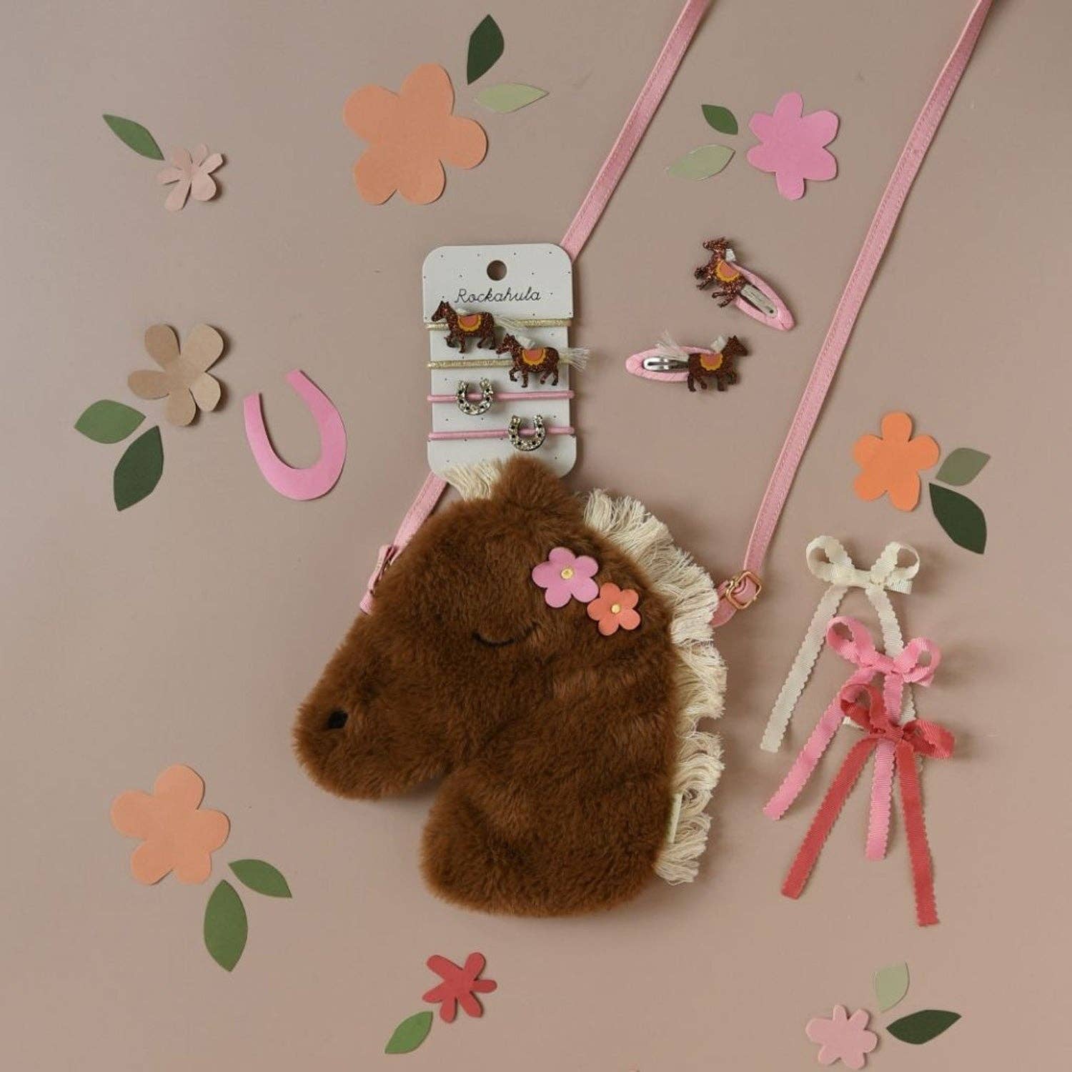Brown plush horse headband with decorative elements on a beige background with flowers and ribbons.
